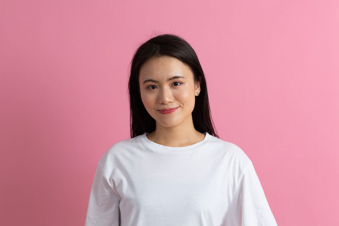 Portrait of Smiling Asian American Woman on Pink Background