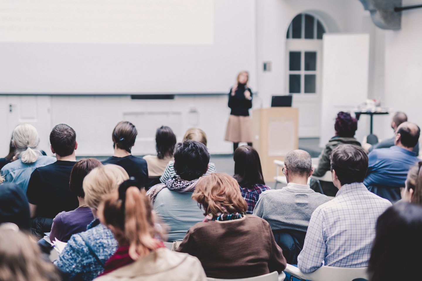 Female Speaker Giving Presentation on Business Conference.